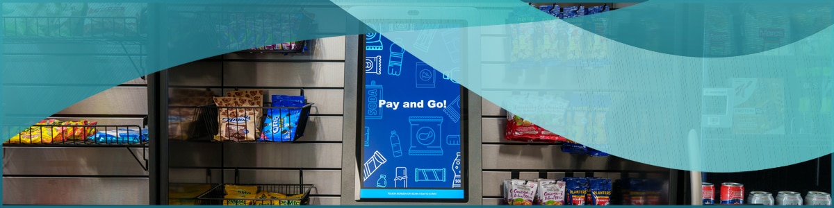 A kiosk in a micro market setting that says "Pay and Go!" on the screen